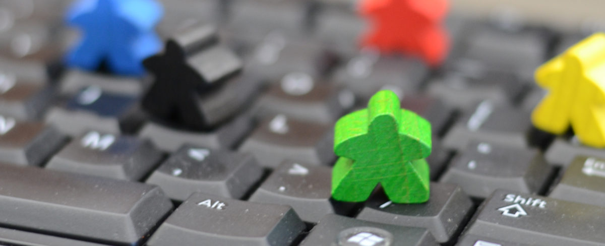 Meeple figures standing on keyboard